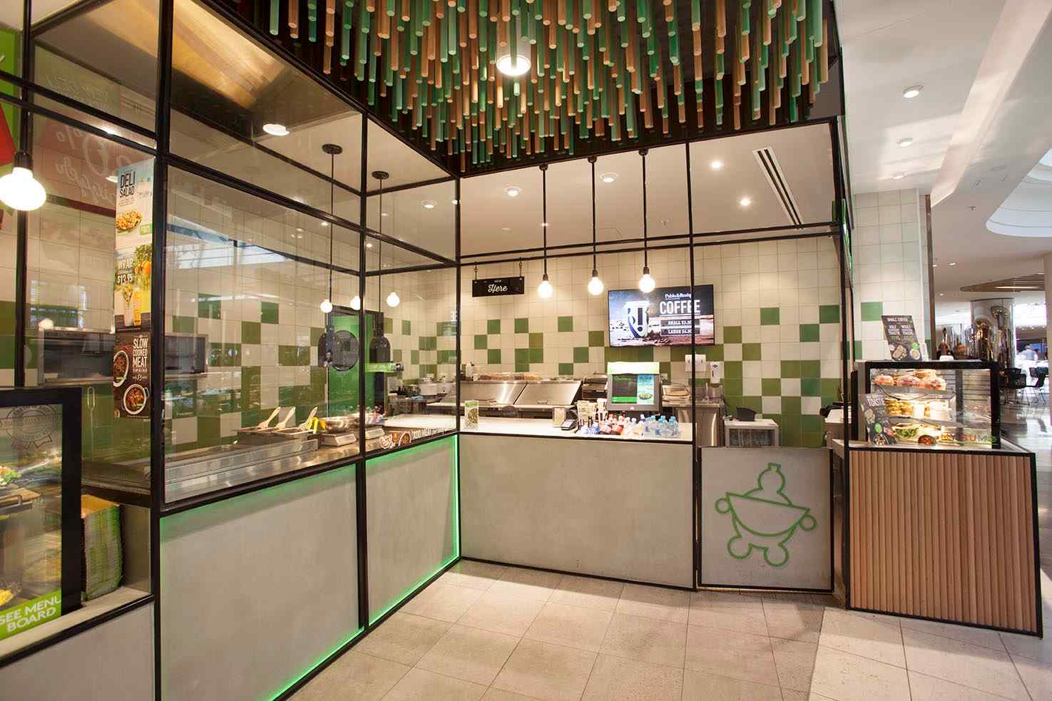 Interior view of the SumoSalad restaurant fit-out at Chadstone Shopping Centre featuring custom commercial joinery, architectural metalwork, feature lighting and customer service areas.