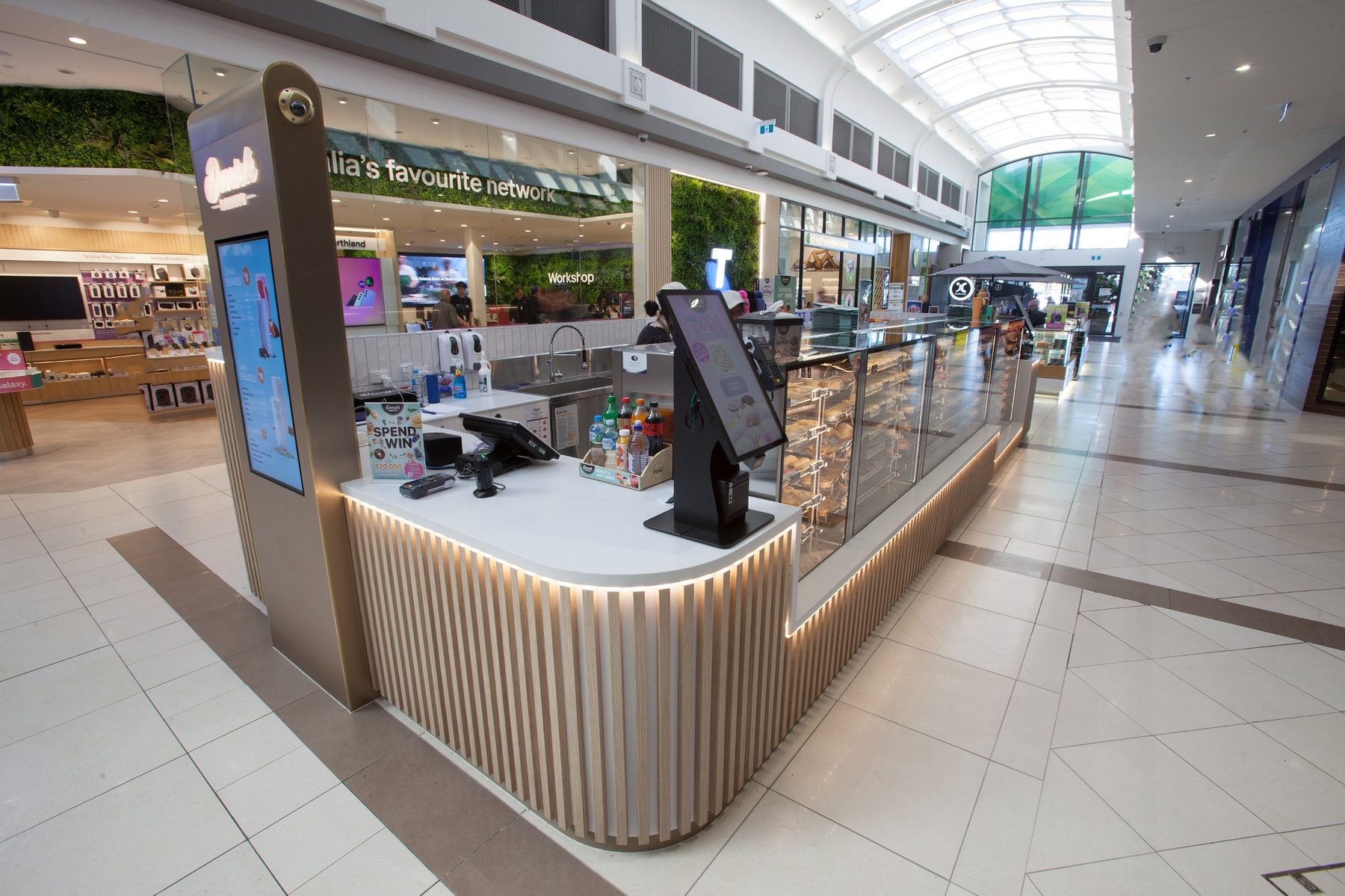 Side perspective of Daniels Donuts shopping centre kiosk with custom joinery and digital ordering screens by Shape Shopfitters.